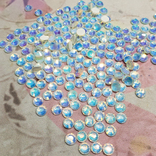 Collection of iridescent rhinestones on a textured fabric background