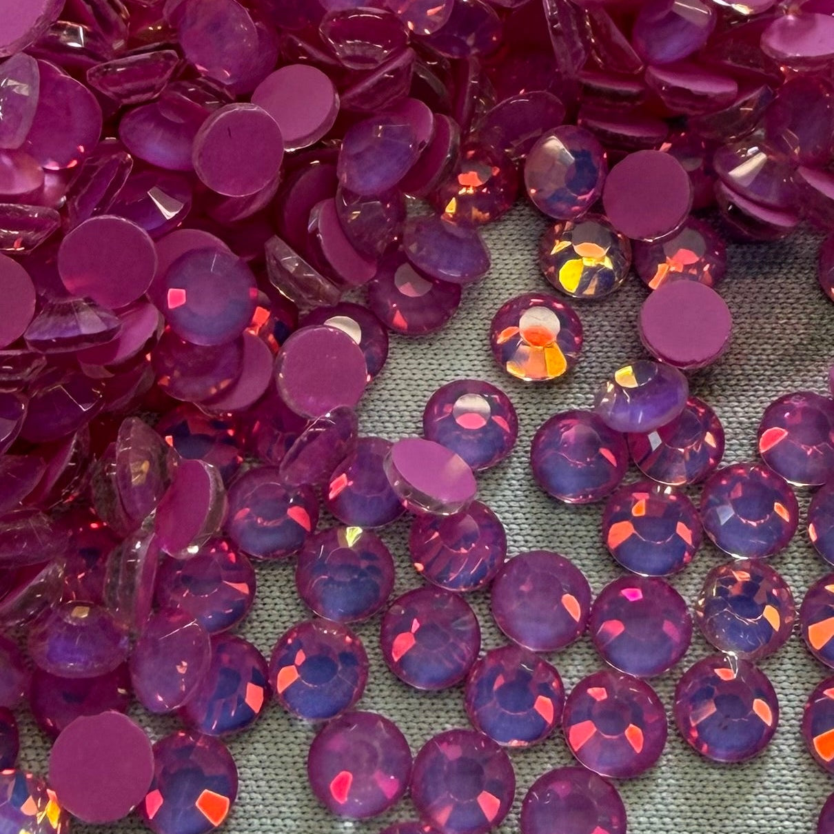 Mocca Dark Rose Opal Pink rhinestones scattered on a gray surface