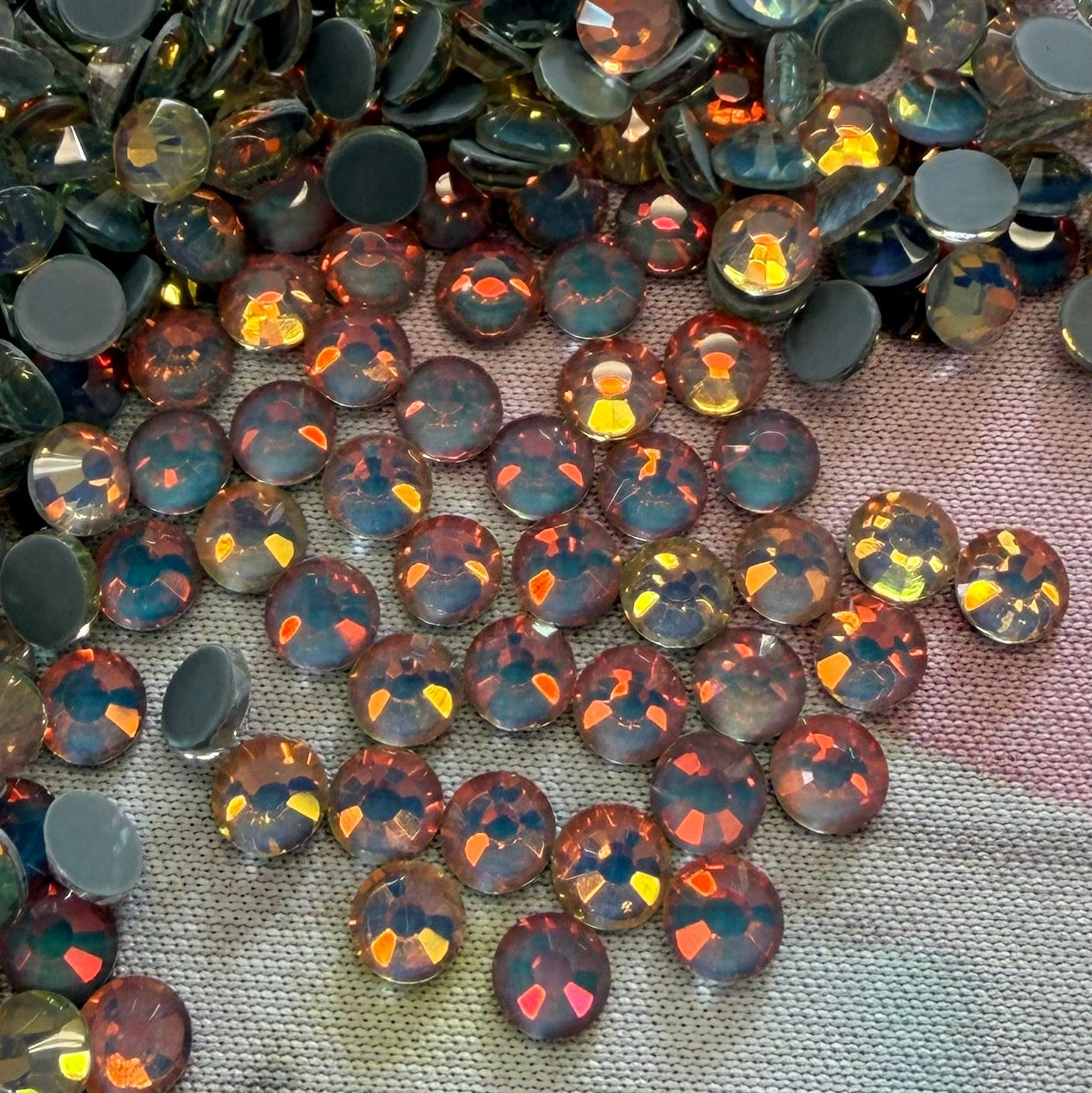 Collection of round, faceted gemstones on a textured fabric background