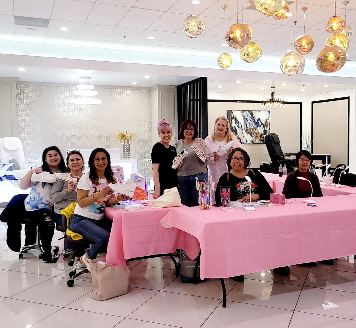 The Crystal Ninja teaching a rhinestone sneaker class, students holding their blinged shoes