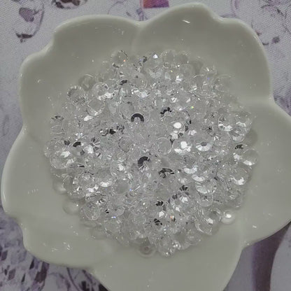 Transparent Clear Unfoiled rhinestones in a glass bowl slowly spinning and sparkling