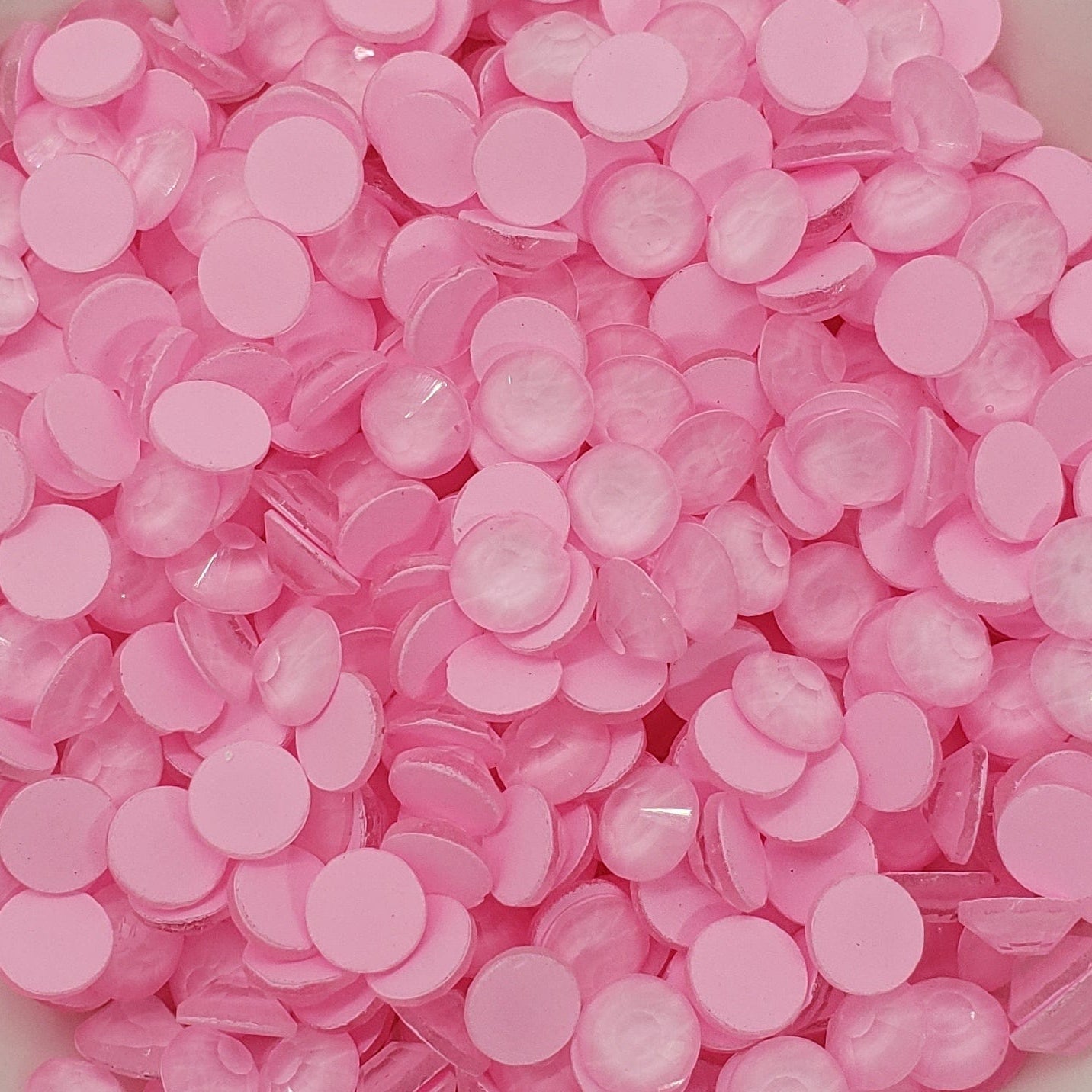 A bowl of pink flat back glass rhinestones.
