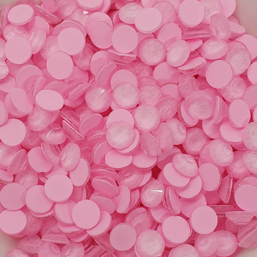 A bowl of pink flat back glass rhinestones.