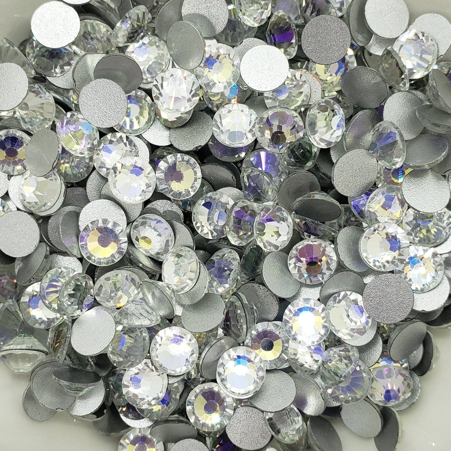 A bowl filled with round blue and clear foiled flatback rhinestones.