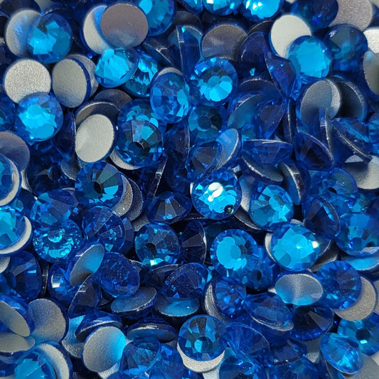 A bowl of blue KiraKira glass rhinestones by CrystalNinja, showcasing their shiny and sparkling appearance.