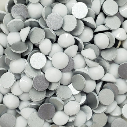 A bowl full of flatback solid white rhinestones intended for crafting and decoration.