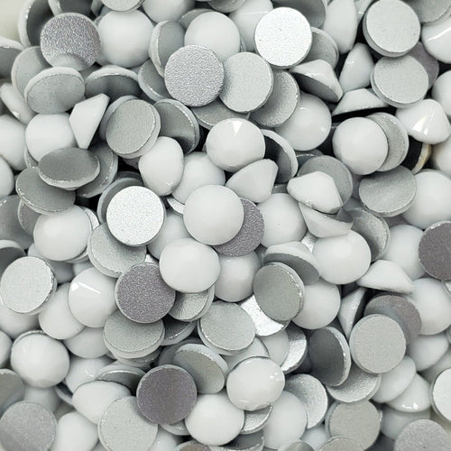 A bowl full of flatback solid white rhinestones intended for crafting and decoration.