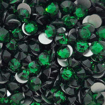 A bowl filled with emerald green KiraKira glass rhinestones.