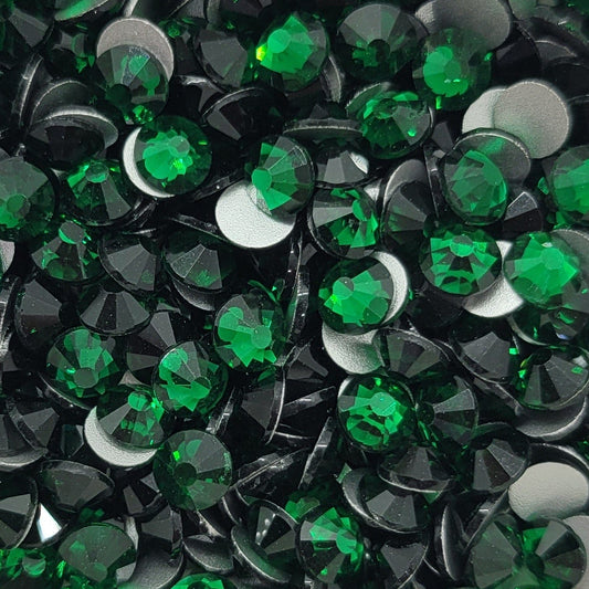 A bowl filled with emerald green KiraKira glass rhinestones.