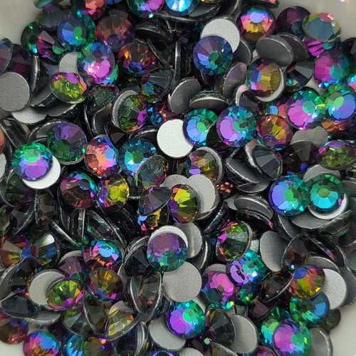 A bowl filled with multicolored round glass rhinestones with a chameleon-like color change effect.