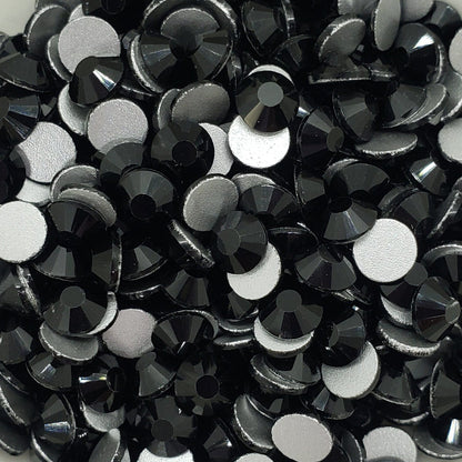 A bowl filled with black flatback glass rhinestones.