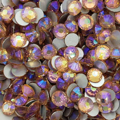 A bowl filled with light peach  AB colored glass rhinestones with a shimmering aurora borealis finish.
