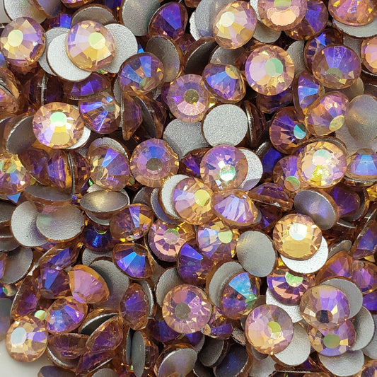 A bowl filled with light peach  AB colored glass rhinestones with a shimmering aurora borealis finish.