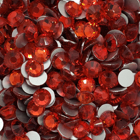 A bowl of red glass rhinestones with a shiny, reflective surface.