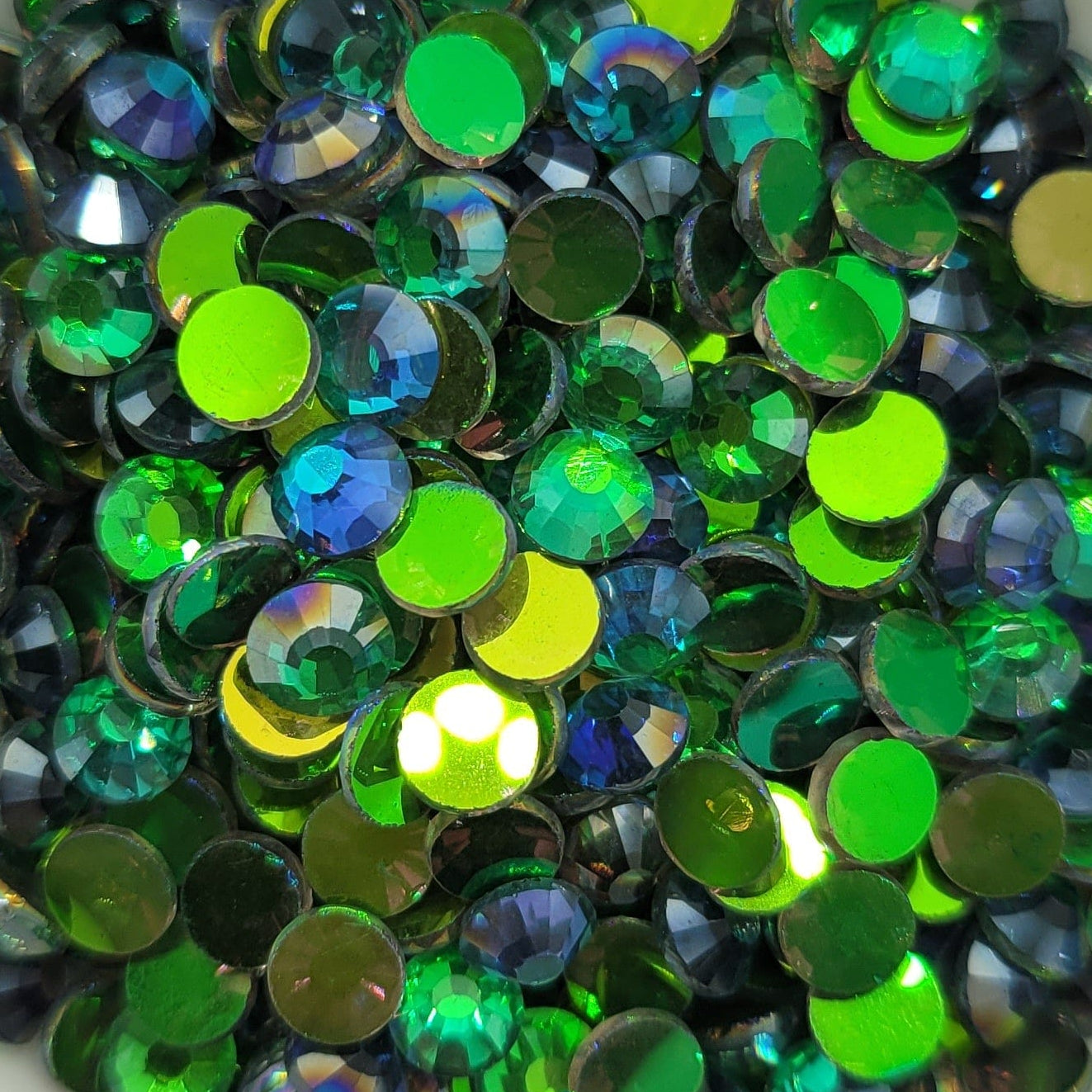 A bowl filled with round metallic antique gold glass pearls with a reflective surface.