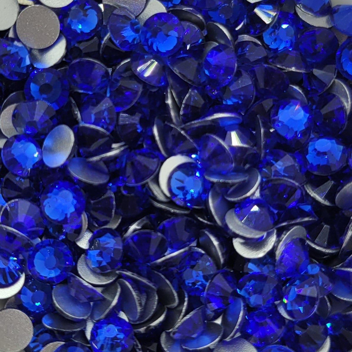 A bowl of blue glass rhinestones intended for crafting purposes.