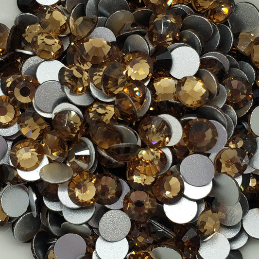 A plate of KiraKira glass rhinestones in shades of brown and gold.