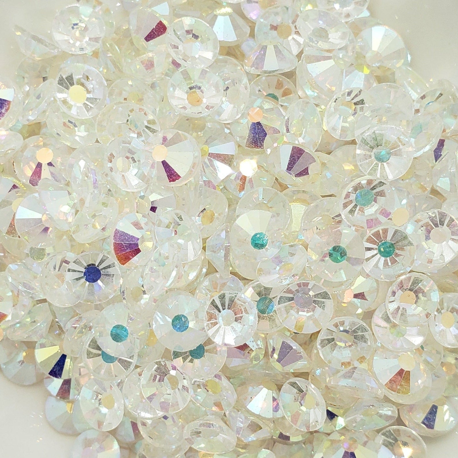 Transparent AB Rhinestones in a white dish on a patterned background
