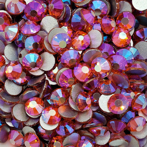 A bowl filled with multicolored flatback rhinestones with a aurora borealis effect.