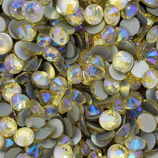 A bowl filled with multicolored flatback rhinestones with a foil backing, intended for crafting and decoration.